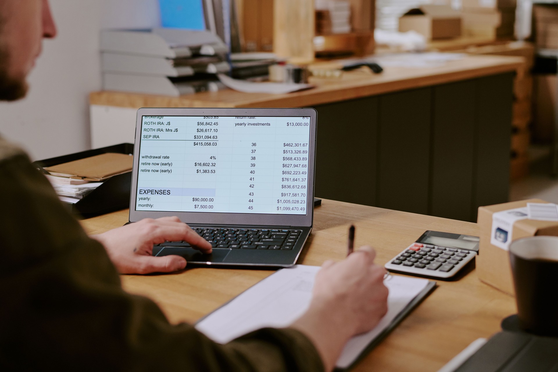 Managing Office Finances on Laptop and Calculator